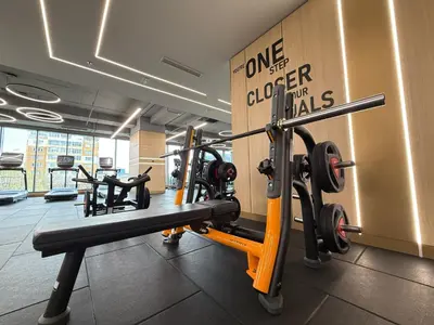 a gym with several tread machines and a sign at East Plaza Hotel in Sofia