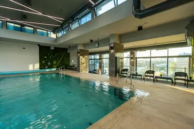a large swimming pool in a large room with windows at East Plaza Hotel in Sofia