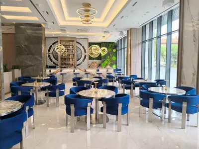 a dining room with tables and blue chairs at East Plaza Hotel in Sofia