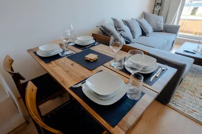 a dining room table with plates and wine glasses at Mountain View Sky Apartment Ori 4 in Sofia