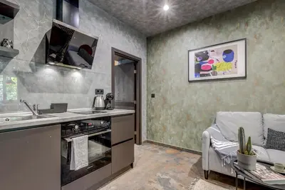 a kitchen with a sink and a stove and a couch at Sophisticated 2BDRM 2BATH and Billiard in Sofia