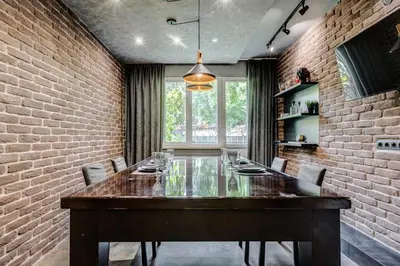 a dining room with a long table and a brick wall at Sophisticated 2BDRM 2BATH and Billiard in Sofia
