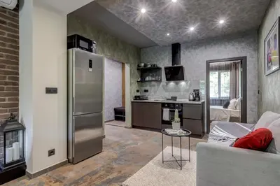 a kitchen with a stainless steel refrigerator in a living room at Sophisticated 2BDRM 2BATH and Billiard in Sofia