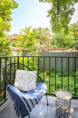 a chair on a balcony with a view of the water at Sophisticated 2BDRM 2BATH and Billiard in Sofia