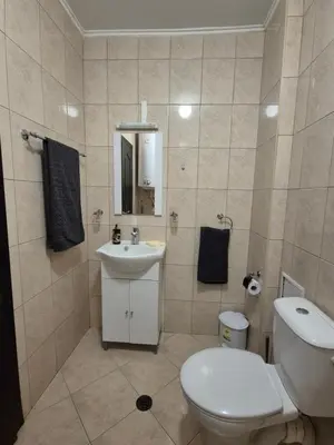 a bathroom with a white toilet and a sink at Studio Kasandra in Hisarya