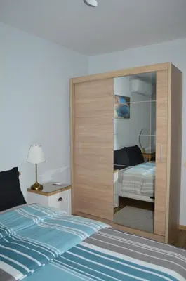 a bedroom with a bed with a large wooden wall at Cozy apartment for overnight stays Hristo Smirnenski in Plovdiv