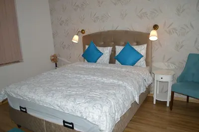 a bedroom with a bed with blue pillows and a blue chair at Cozy apartment for overnight stays Hristo Smirnenski in Plovdiv