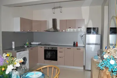 a kitchen with a sink and a refrigerator and a table at Cozy apartment for overnight stays Hristo Smirnenski in Plovdiv