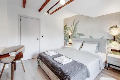 a bedroom with a white bed and a chair at City Gem 1BDRM 200m Sofia Statue in Sofia
