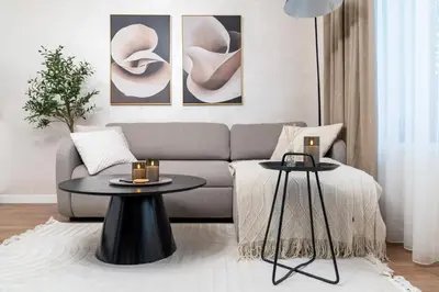 a living room with a couch and two tables at Бизнес & Арт апартамент - до Панаира и Капана in Plovdiv