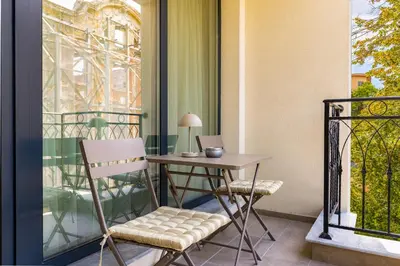 a table and chair on a balcony with a table and a window at Downtown Modern Studio with Balcony by Flat Mаnager in Plovdiv