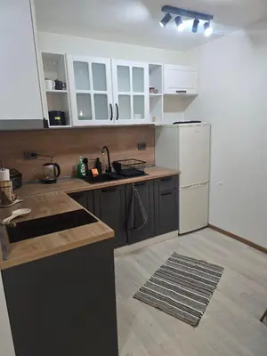 a kitchen with white cabinets and a white refrigerator at Peshtera Cozy Apartment in Peshtera