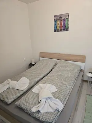 two beds with towels on them in a bedroom at Peshtera Cozy Apartment in Peshtera