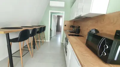 a kitchen with a counter and stools in it at Magnika in Sapareva Banya