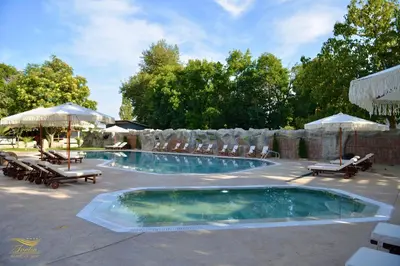 a large swimming pool with chairs and umbrellas at Ивелия Хотел и Спа - Ivelia Hotel & SPA in Dŭbnitsa