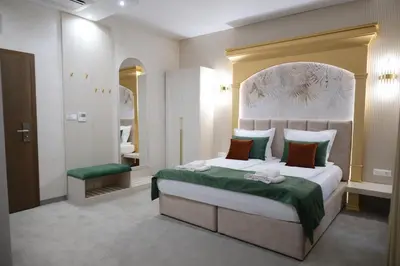 a bedroom with a large bed with a green blanket at Ивелия Хотел и Спа - Ivelia Hotel & SPA in Dŭbnitsa