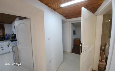 a kitchen with white walls and a wooden ceiling at Guest Suite SUZY in Petrich