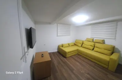 a living room with a yellow couch and a tv at Guest Suite SUZY in Petrich
