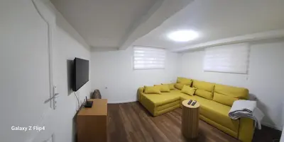 a living room with a yellow couch and a tv at Guest Suite SUZY in Petrich