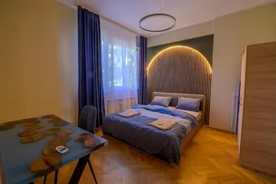 a bedroom with a bed and a table and a window at 2 DeLuxe Apartments, Top Center Free Parking, 4 BDR in Sofia
