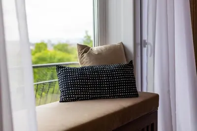 a pillow sitting on a bench in front of a window at Art Retreat Zaimov in Sofia
