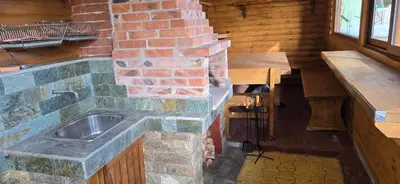 a stone kitchen with a sink and a brick wall at Villa Margarita 1 in Semkovo