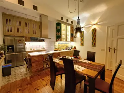 a kitchen with a wooden table and a dining room at Cultural Monument residence in Doktorska Gradina in Sofia