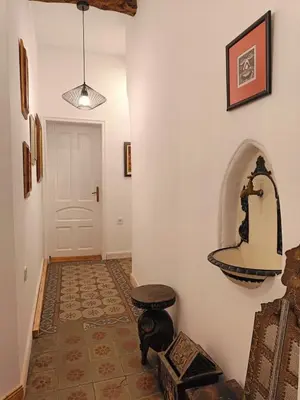 a hallway with a table and a sink on the wall at Cultural Monument residence in Doktorska Gradina in Sofia