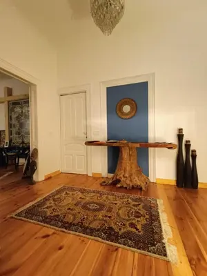 a room with a table and a rug on a wooden floor at Cultural Monument residence in Doktorska Gradina in Sofia
