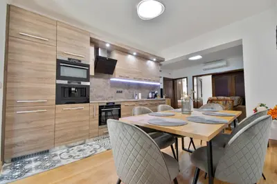 a kitchen and dining room with a wooden table and chairs at Apartment Central in Plovdiv