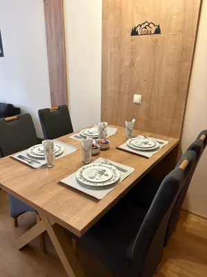 a wooden table with chairs and plates on it at Apartment GORA in Borovets