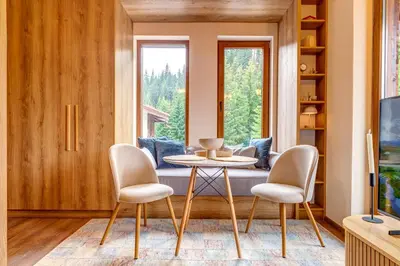 a living room with a table and chairs and a couch at Mountain Luxe Studio by Flat Manаger in Pamporovo