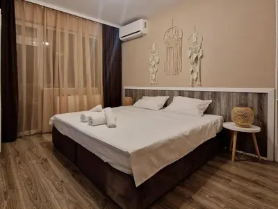 a bedroom with a large bed with white sheets at къща за гости Рока in Mineralni Bani