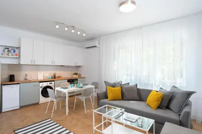 a living room with a gray couch and a table at Starflat Gorgeous central apartment next to NDK in Sofia