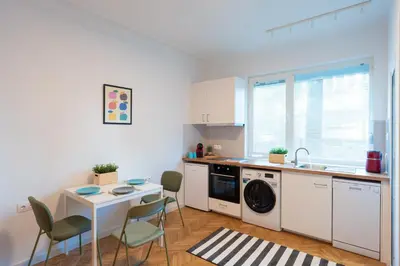a kitchen with a washing machine and a table and chairs at Starflat Gorgeous central apartment next to NDK in Sofia