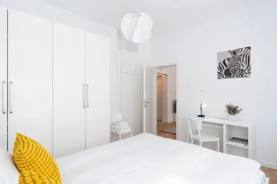 a white bedroom with a white bed and a desk at Starflat Gorgeous central apartment next to NDK in Sofia