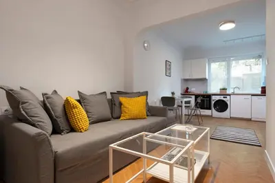 a living room with a gray couch with yellow pillows at Starflat Gorgeous central apartment next to NDK in Sofia