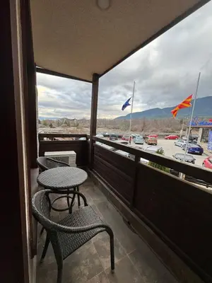 a balcony with a table and chairs and flags at Gondola Vibes in Bansko