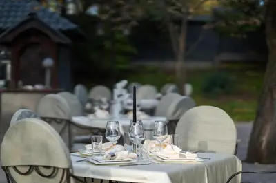 a group of tables with wine glasses and napkins at Stillaterm SPA in Mineralni Bani