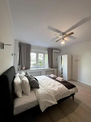 a bedroom with a bed with a ceiling fan at Modern 100m Apt In Sofia Center Vitosha Blvd in Sofia