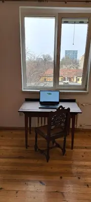 a laptop computer sitting on a table in front of a window at Bright apartment in Doktorska gradina in Sofia