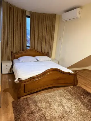 a bedroom with a large wooden bed and a window at Central Mansard Studio in Sofia