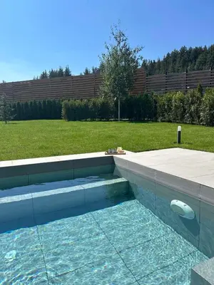 a swimming pool in a yard next to a field at Aquaterra Villa with Hot Pool - Banya in Banya