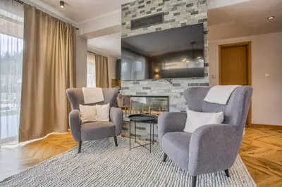 two chairs and a table in a living room with a fireplace at Aquaterra Villa with Hot Pool - Banya in Banya