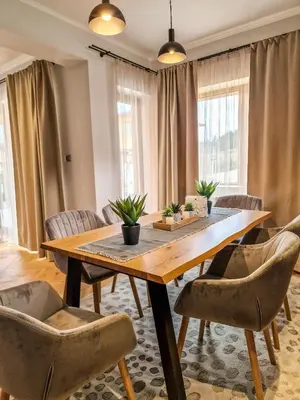 a dining room with a wooden table and chairs at Aquaterra Villa with Hot Pool - Banya in Banya