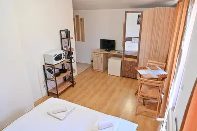 a small room with a bed and a desk with a microwave at Charming Studio with Mountain View - Bansko by Flat Mаnаger in Bansko