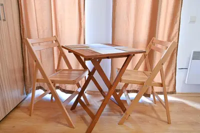 a wooden table with two chairs next to a curtain at Charming Studio with Mountain View - Bansko by Flat Mаnаger in Bansko