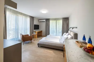a hotel room with a bed and a living room at Nik Palas Luxury Residence in Sandanski