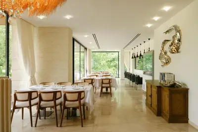 a dining room with tables and chairs and windows at Nik Palas Luxury Residence in Sandanski