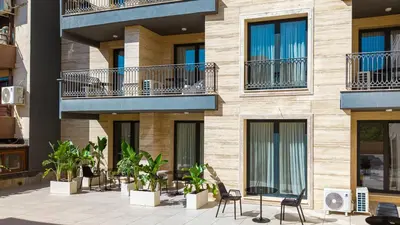 a building with chairs and plants in front of it at Nik Palas Luxury Residence in Sandanski